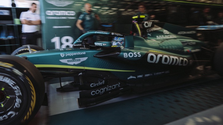 Carro de Fórmula 1 da Aston Martin Honda no box, com a equipe trabalhando
