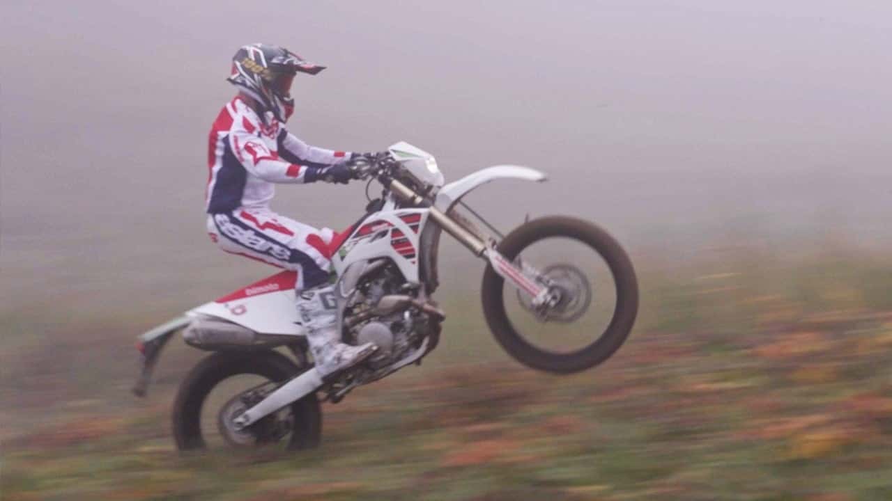 Bimota BX450 2024 em trilha de terra com paisagem de montanha