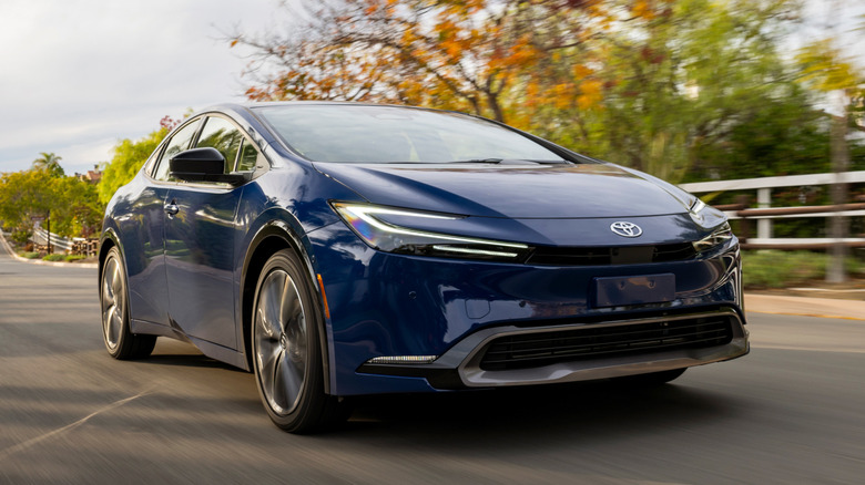 Vários sedãs híbridos de 2026, incluindo Toyota Prius, Honda Civic e Hyundai Elantra, em uma estrada.