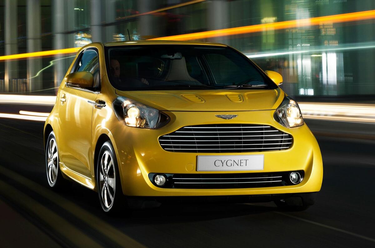 Aston Martin Cygnet azul em estrada com Ford Pinto ao fundo