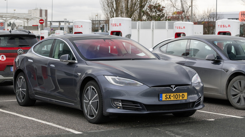 Carregador supercharger da Tesla com carros elétricos carregando em estações