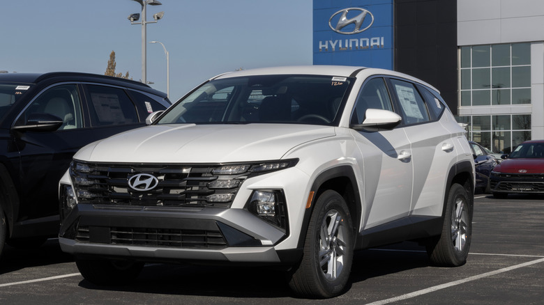 SUV Hyundai Tucson e Kia Sportage estacionados em uma concessionária