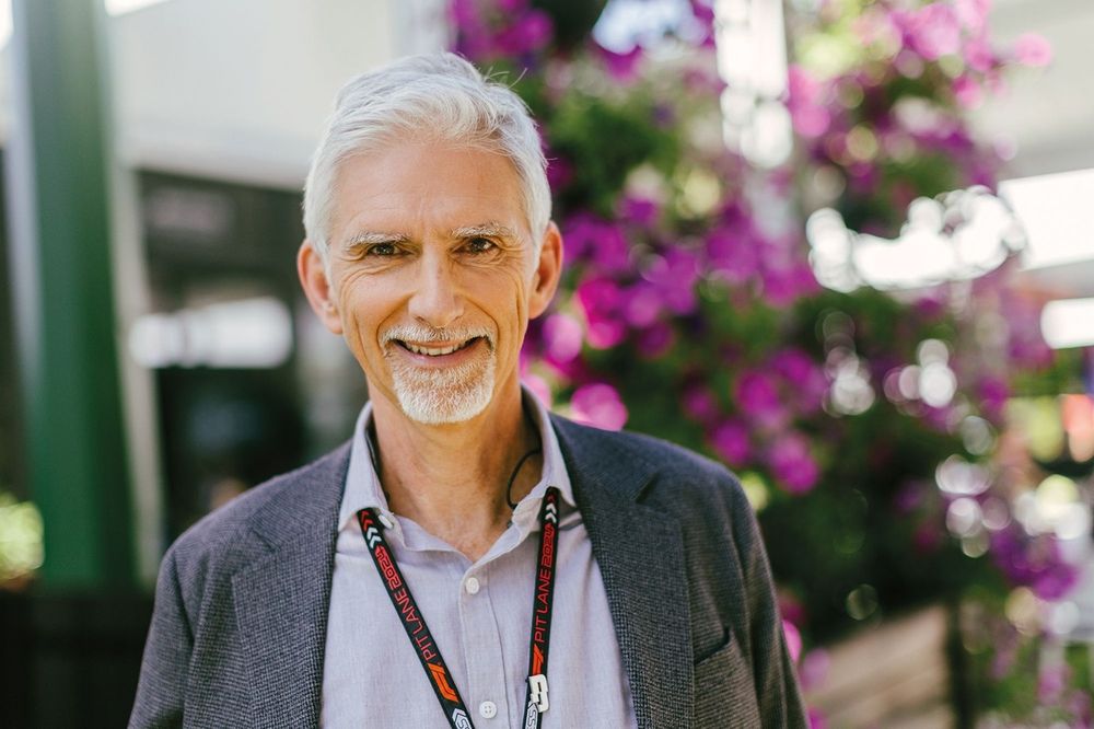 Damon Hill em close-up, sorrindo e usando boné da Williams