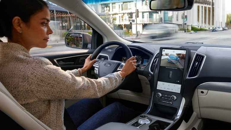 Vários veículos Ford estacionados em uma fila, incluindo picapes e SUVs, indicando a vasta gama de modelos afetados pelos recalls.