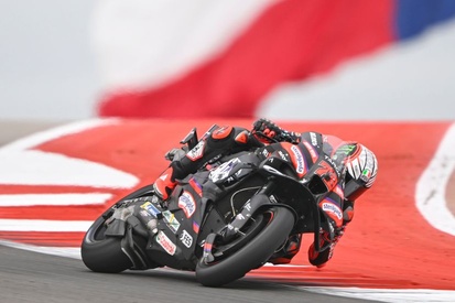 Marco Bezzecchi em sua Aprilia, acelerando em curva