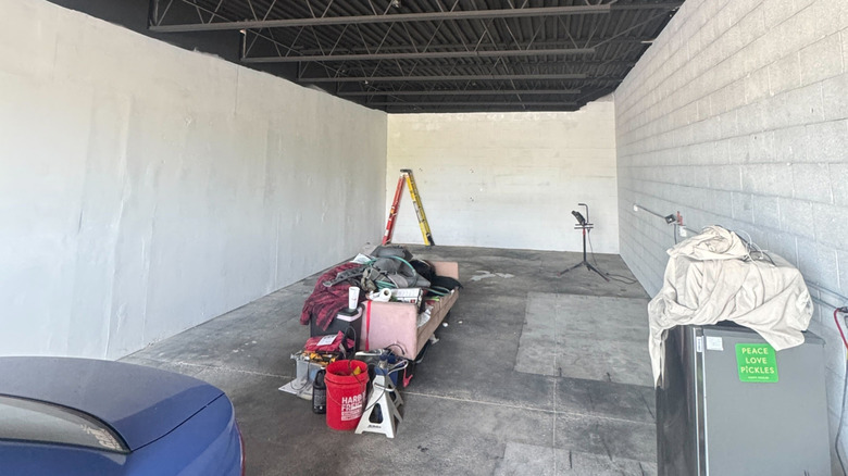 Vista da oficina após a pintura e limpeza, com paredes escuras e piso limpo