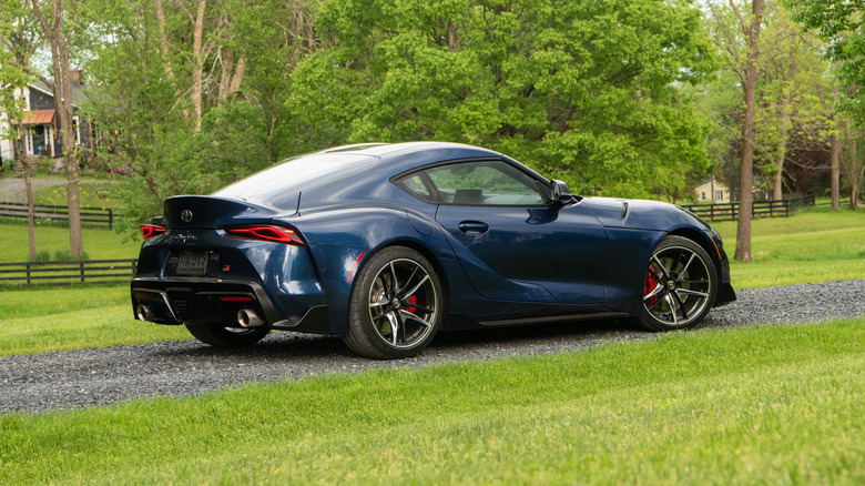 Tuning — Toyota Supra Mk IV branco estacionado, mostrando suas linhas clássicas e o aerofólio
