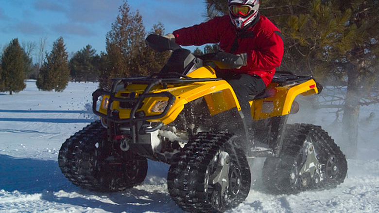 ATV equipado com esteiras para neve em uma trilha