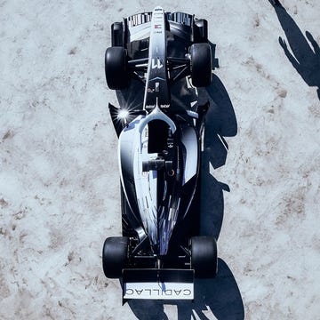 Carro de corrida com pintura azul e branca em alta velocidade na pista