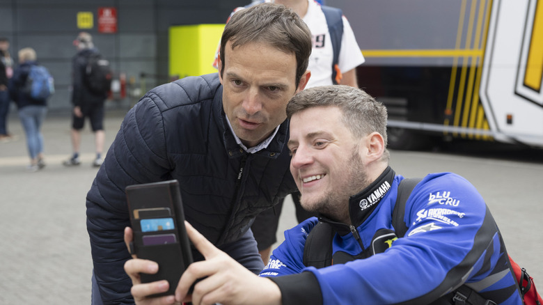 Vários pilotos de MotoGP reunidos, conversando no paddock