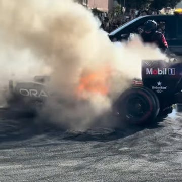 Carro de Fórmula 1 RB7 com chamas no motor