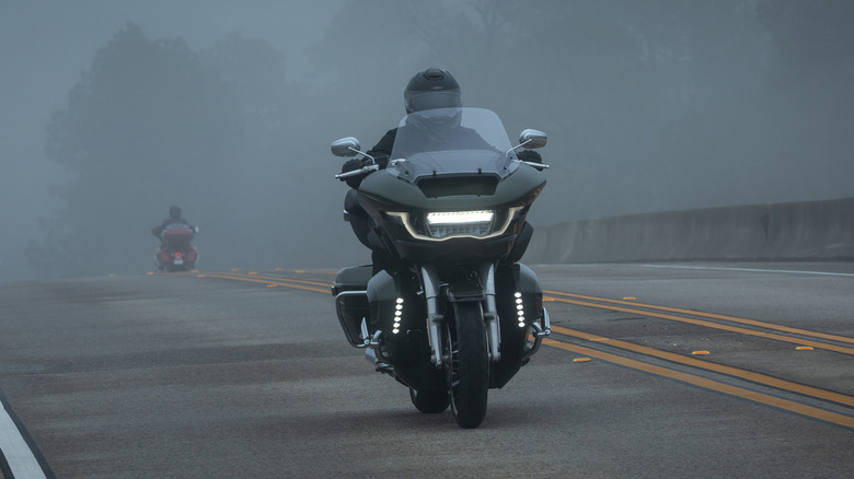 Harley-Davidson Road Glide Limited 2026 preta em estrada com floresta ao fundo