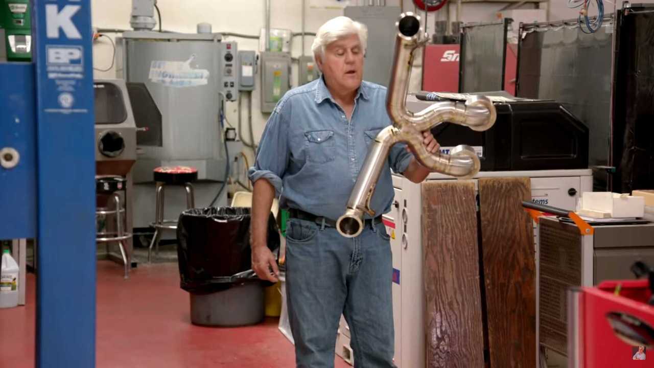 Jay Leno em sua oficina, rodeado por carros clássicos e ferramentas