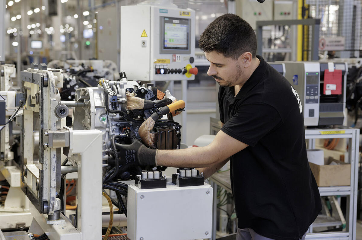 Vista detalhada de um motor automotivo em processo de montagem na linha de produção, com foco nos componentes internos e na complexidade da engenharia.