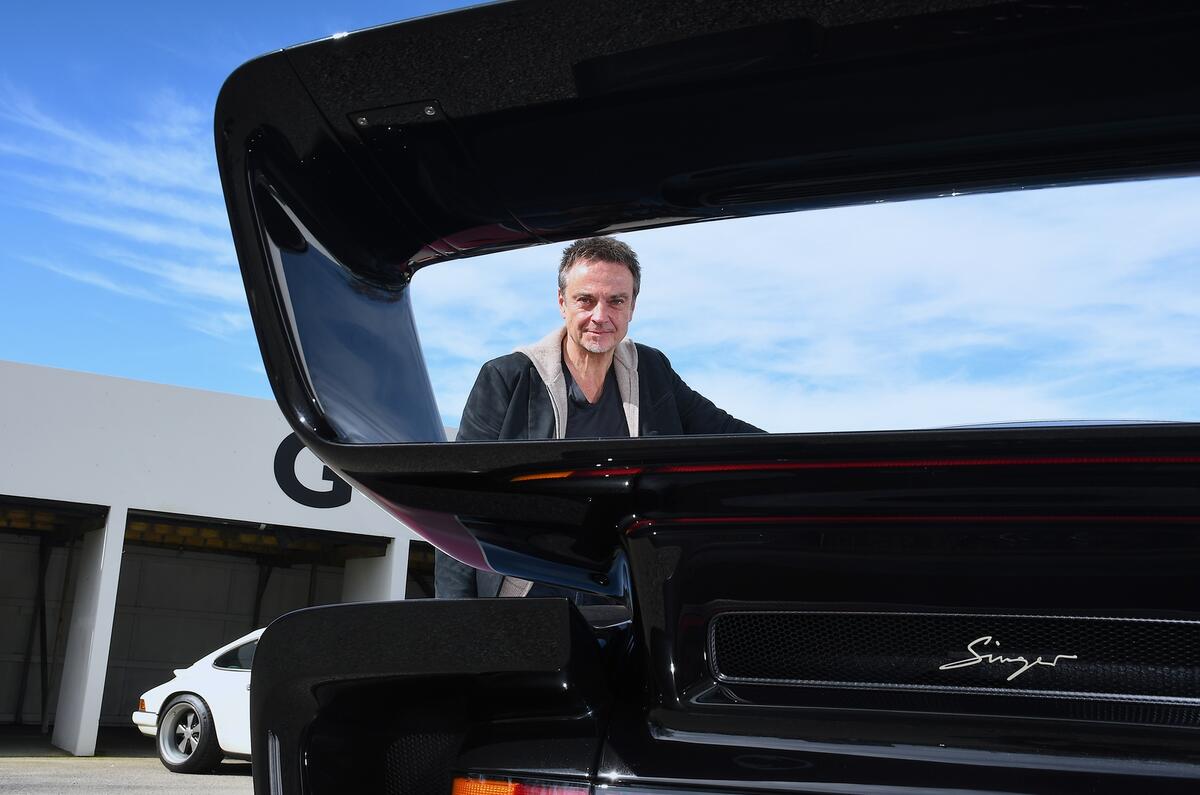 Rob Dickinson, fundador da Singer, sorri ao lado de um de seus Porsches 911 customizados