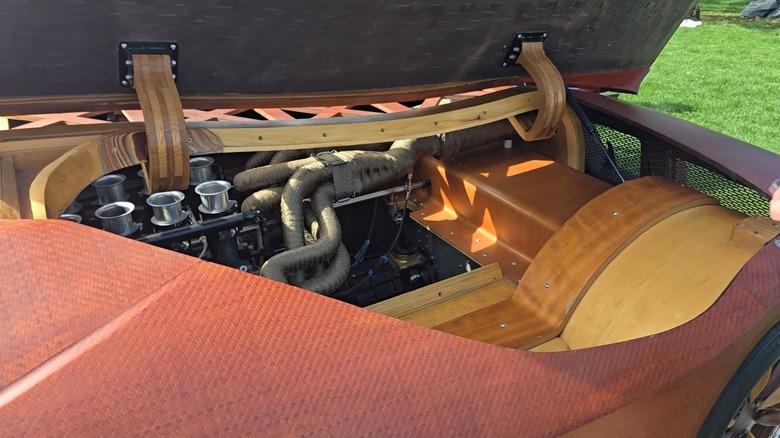 Compartimento do motor do Splinter, destacando a estrutura de madeira e o sistema de exaustão
