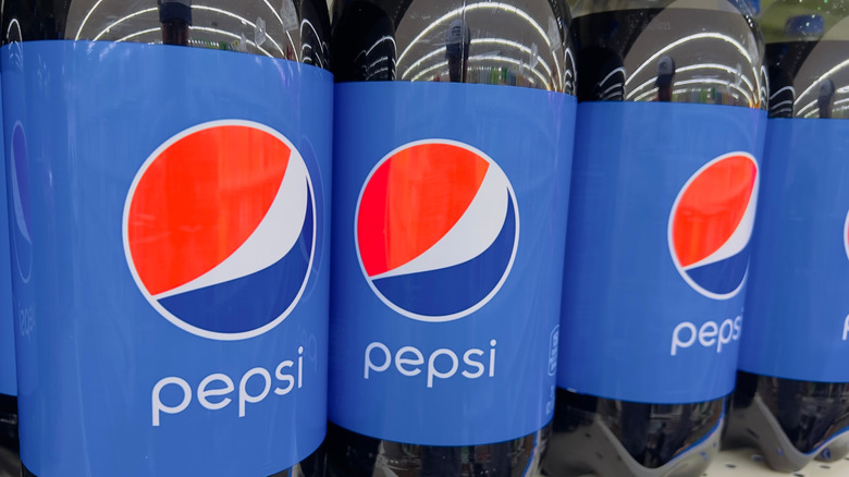 Radiador de carro sendo preenchido com garrafas de Pepsi cola