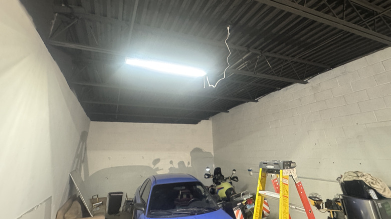 Detalhe da instalação das novas luminárias LED interligáveis no teto da oficina
