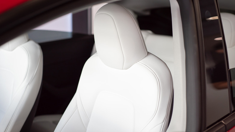 Interior de carro com bancos de couro sintético branco e detalhes em preto