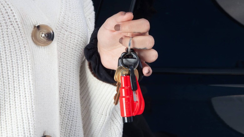 Vários gadgets automotivos dispostos em uma superfície escura, incluindo um carregador portátil e outros acessórios.