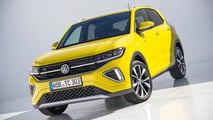 VW T-Cross 2026 em uma rua urbana, mostrando o modelo a combustão para comparação.