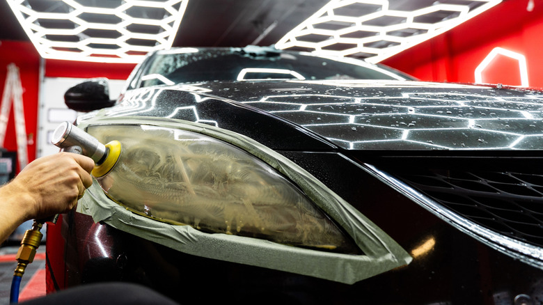 Farol embaçado de um carro, evidenciando a perda de transparência