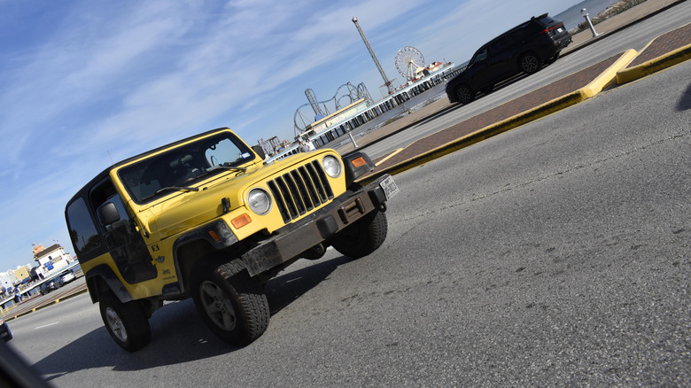 Mulher com óculos de sol em um carro conversível amarelo