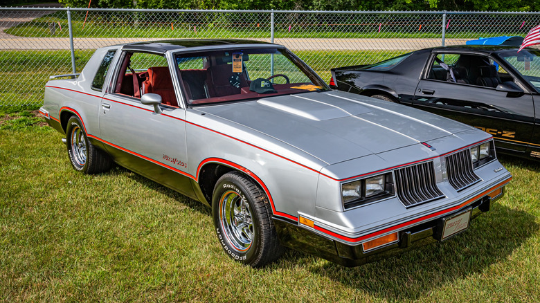 Painel interno do Oldsmobile Cutlass G-body 1983 com as três alavancas de câmbio Hurst Lightning Rods